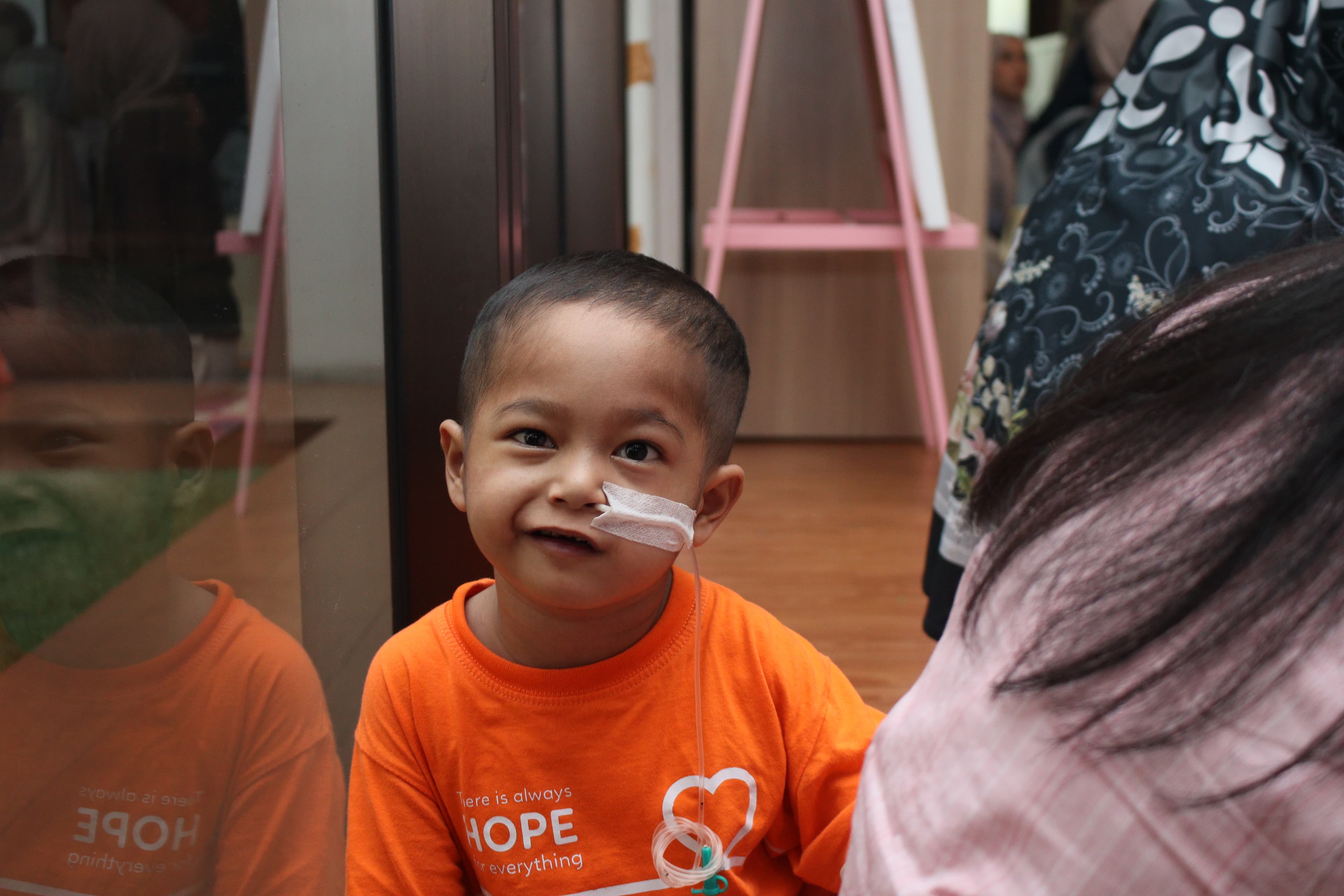Seorang anak dengan senyum harapan bersama relawan Panti Goceng